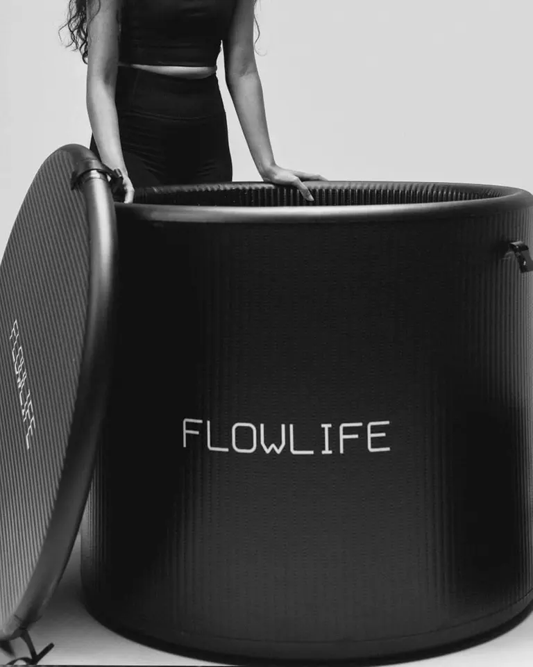 Black Flowplunge Pro cold plunge tub with reinforced drop-stitch walls and a protective lid for ice bath recovery.