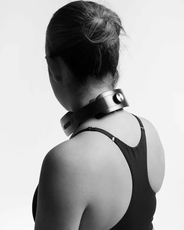 Flowtens Neck TENS and EMS device in black, featuring a rotating crown for electrode adjustment, shown in a back-view shot.