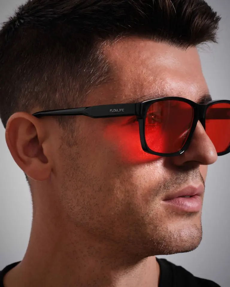 A close-up side profile of Álvaro Morata wearing Flowglasses Night Sync 02 - Morata Edition with red lenses and black frames.