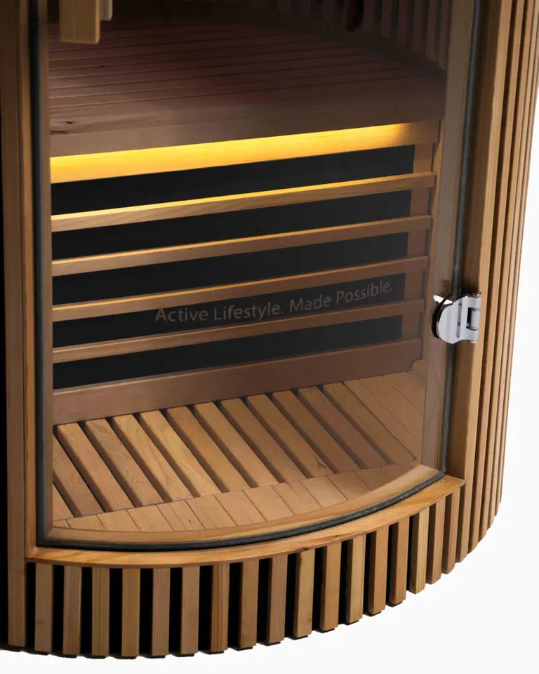 Flowsauna Elite Solo interior featuring hemlock wood slats, a curved glass door with chrome latch, and warm LED lighting.