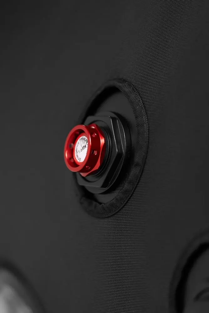 Red emergency pressure relief valve on the black soft-shell fabric of the Flowchamber Oxygen Elite 170 Soft-Shell.