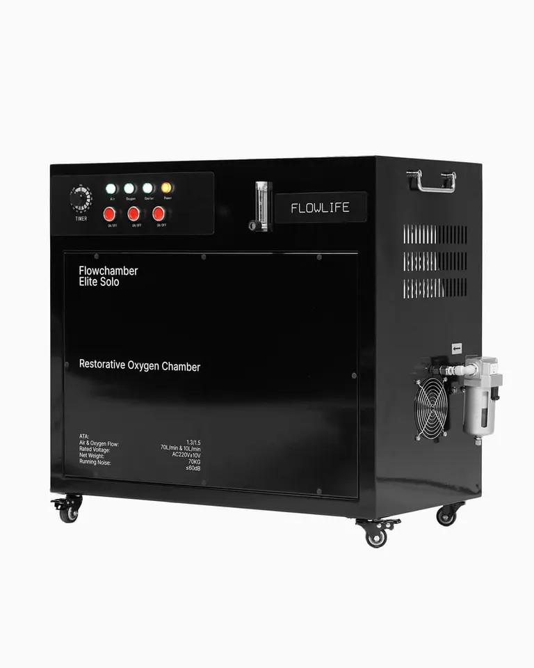 Black all-in-one compressor and oxygen system for Flowchamber, featuring a control panel, timer, and mobile wheels.