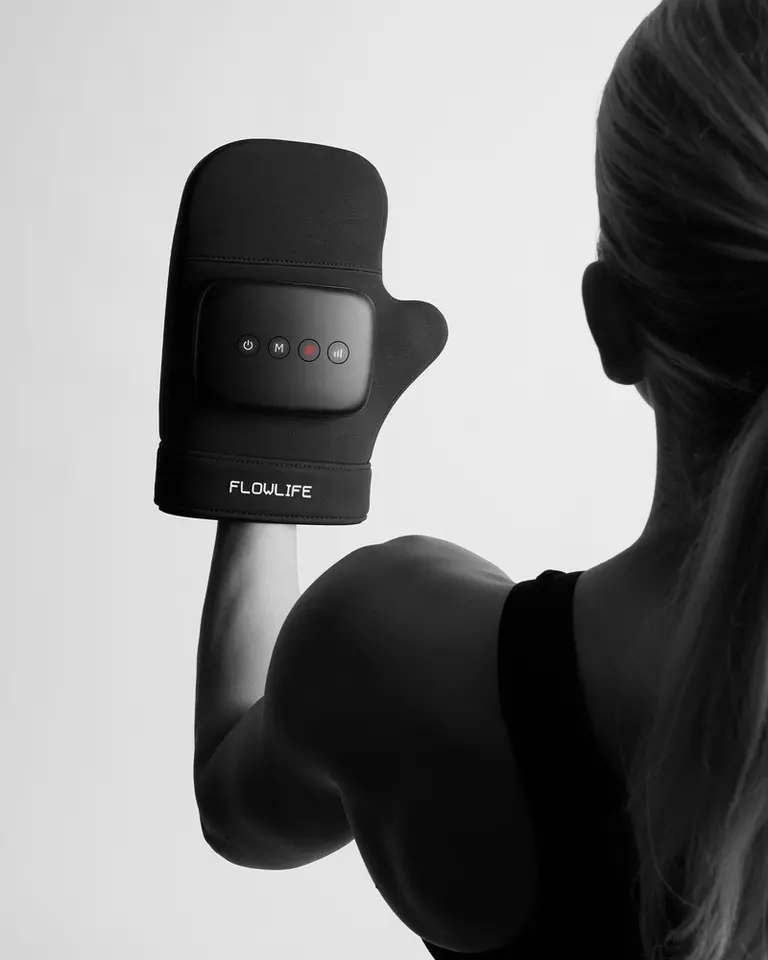 Flowpression Hand on a woman’s hand, featuring a control panel for rhythmic air pressure and heat therapy.