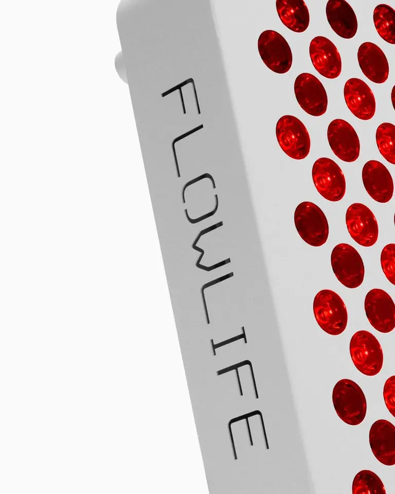 Side view of the white Flowlight 300 Two Waves red light therapy panel with red LEDs and engraved Flowlife logo.