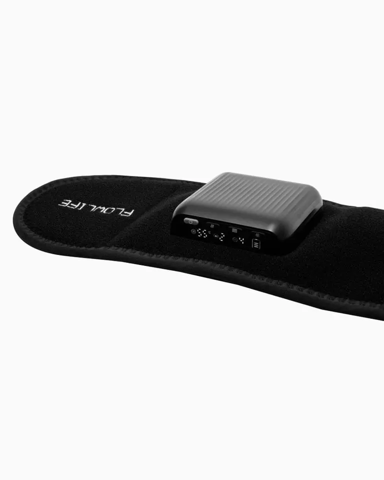 Flowtherma Belt with a close-up of the black control unit displaying settings for heat and vibration therapy.
