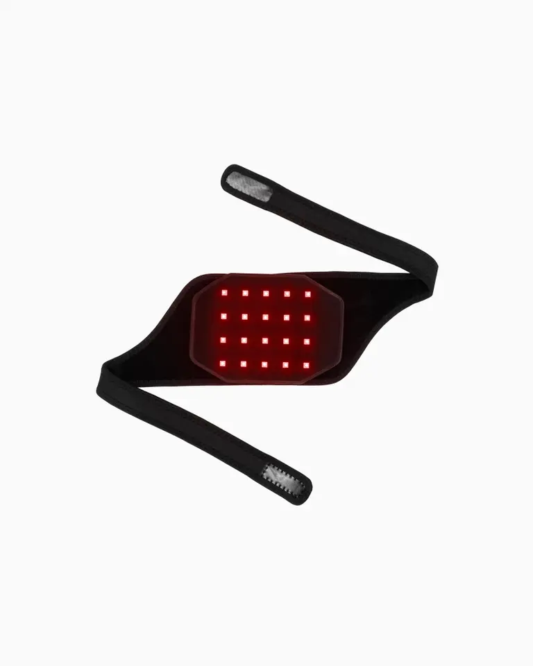 Flowtherma Spot featuring glowing red-light LEDs on an adjustable black strap for targeted muscle recovery.