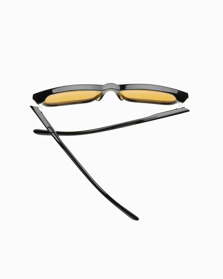 Flowglasses Day Sync 02 - Álvaro Edition featuring a black frame and amber lenses, shown from a top-down perspective.