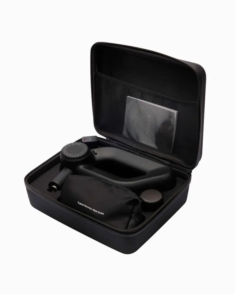 Flowgun Ultra percussion massage gun and accessories neatly organized inside an open black carrying case with manual.