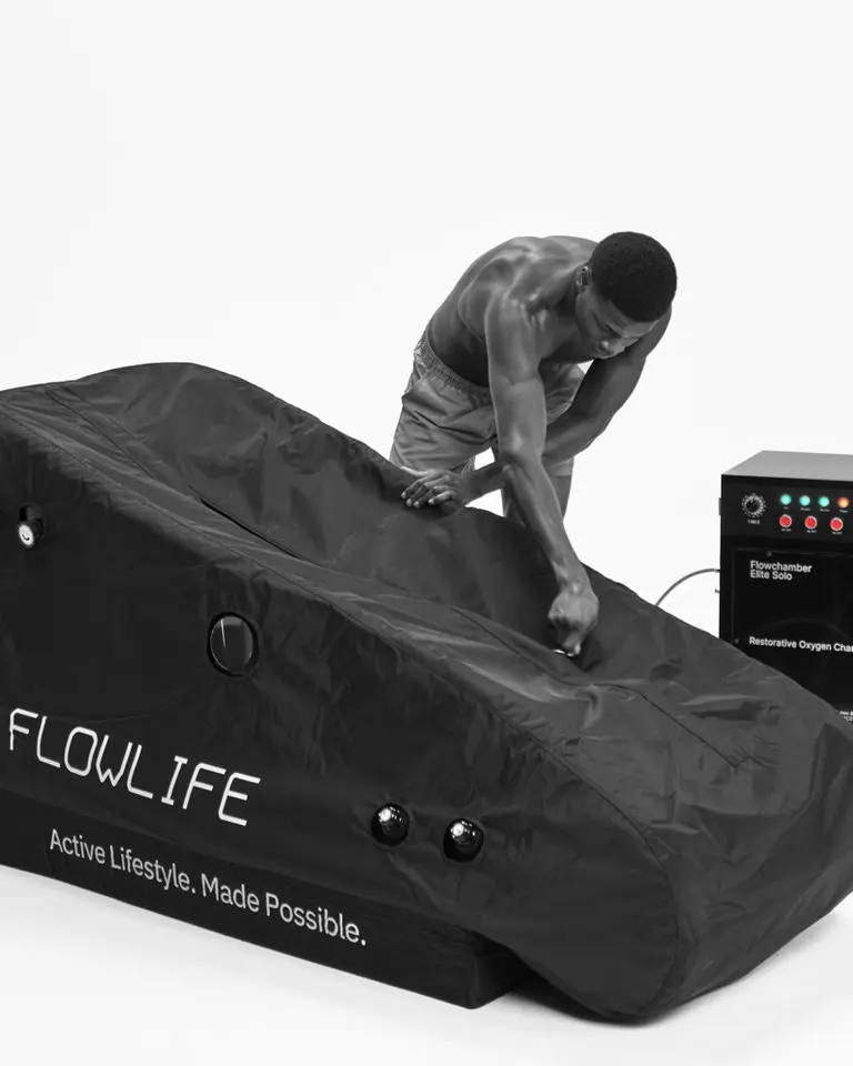 A man prepares the black Flowchamber Oxygen Elite 226 Soft-Shell, a soft-shell hyperbaric oxygen chamber, for recovery.