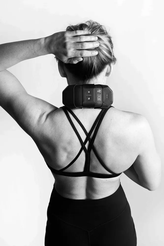 A woman wearing the black Flowcontrast Spot Go on her neck for contrast therapy, shown from behind in black and white.