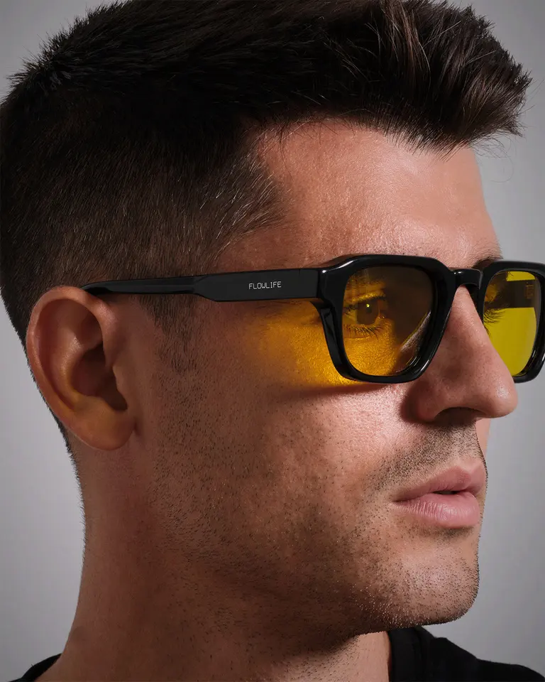 A close-up profile view of Álvaro Morata wearing the Flowglasses Day Sync 03 with amber lenses and a black frame.