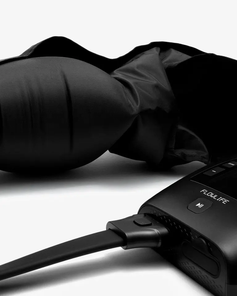 Black Pro+ Arm Attachment sleeve connected to a Flowpression unit, showing the hose interface and durable fabric.