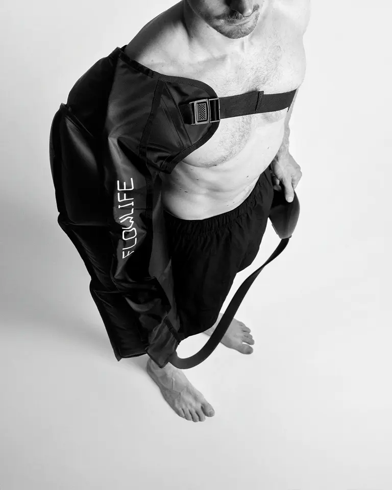 Pro+ Arm Attachment black compression sleeve for Flowpression, worn with an adjustable strap for arm recovery.